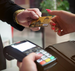 Client handing over card to card attendant to swipe it | The Power of Outsourced Financial Modelling | CFOD Hub news and articles
